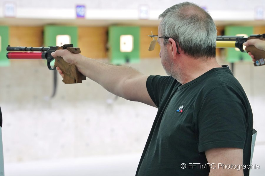Hervé au pas de tir, concentré et bras tendu avec son pistolet vers la cible